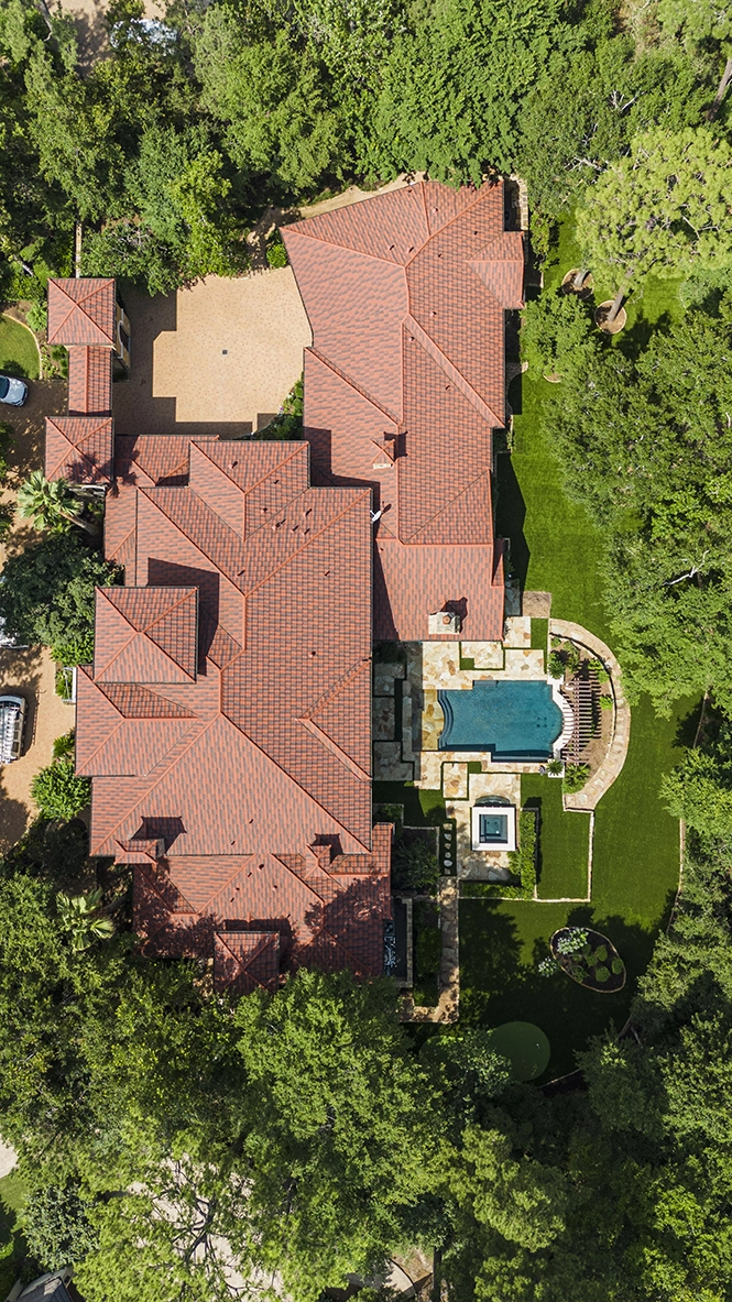 Aerial view of a luxury residential estate featuring a pool, manicured lawns, custom landscape design, and resort-style outdoor living spaces.