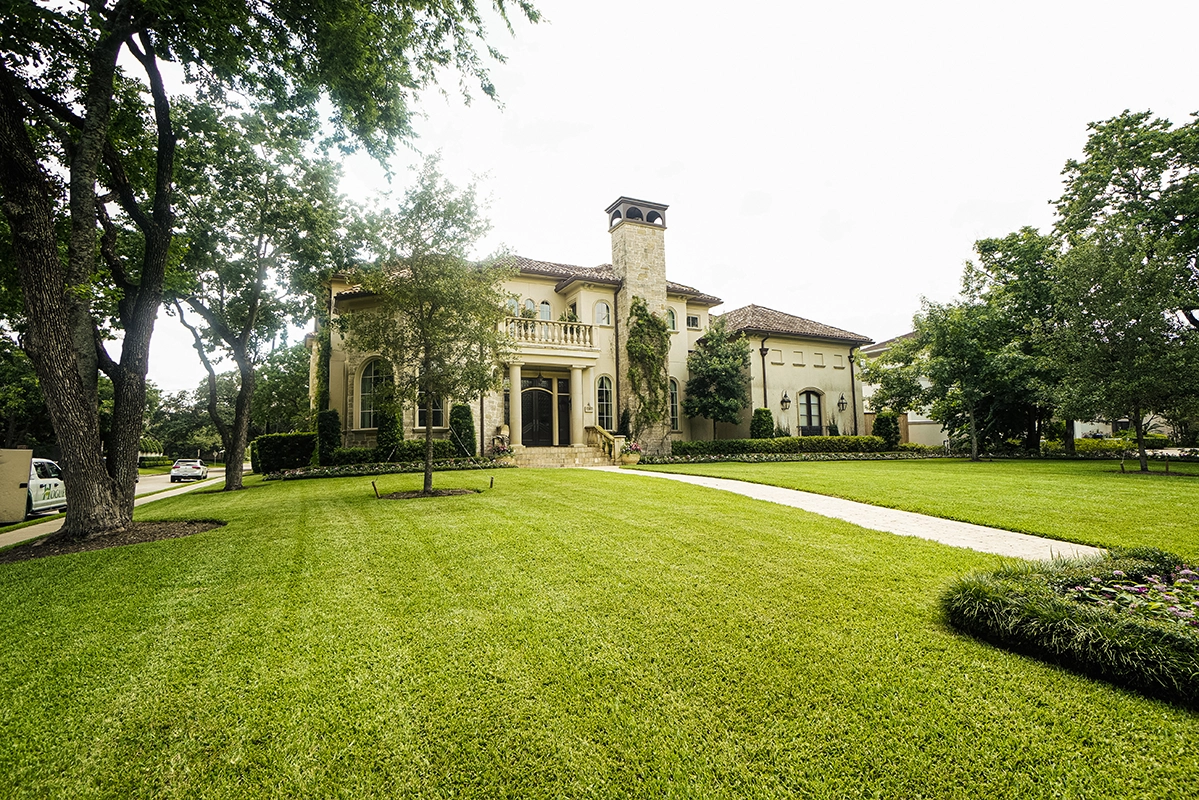 A home managed by Hogue with mature trees, landscaped beds and a maintained green lawn