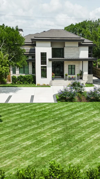Modern residential landscape installation with manicured turf, custom planting design, and luxury curb appeal.